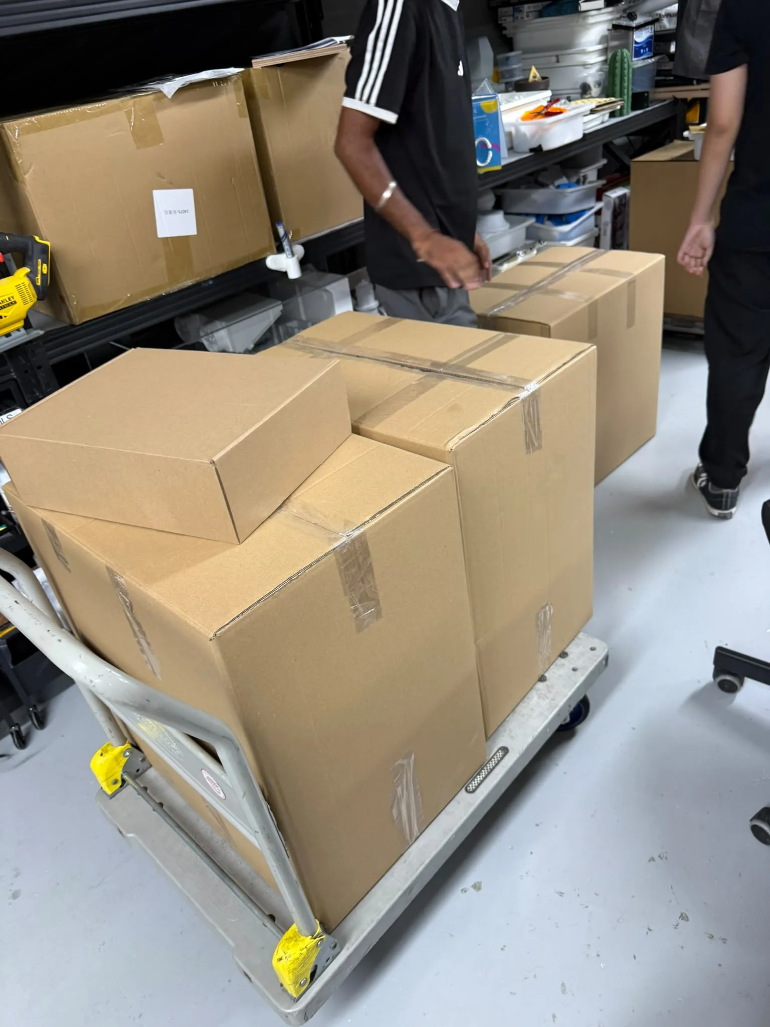 Taped cardboard boxes stacked on a trolley in the studio, ready to go out