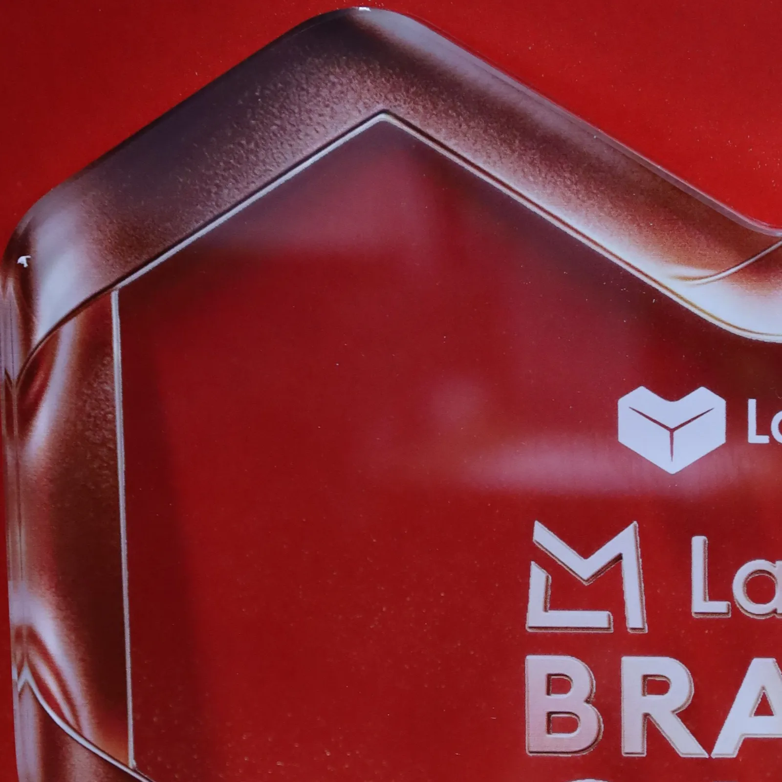 Close-up of the heart's top corner: the rose-red printed band fading towards clear acrylic, beside the Lazada and LazMall logos