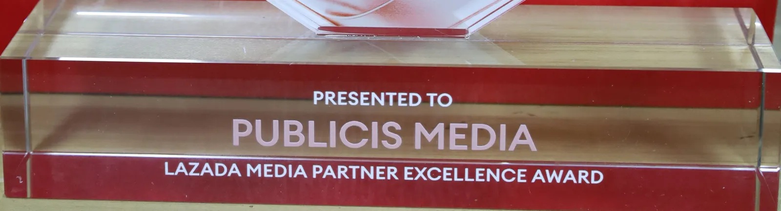 Close-up of the clear acrylic base reading PRESENTED TO PUBLICIS MEDIA, LAZADA MEDIA PARTNER EXCELLENCE AWARD