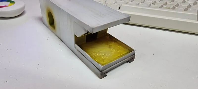 The printed carriage on a desk without its base, the open bay at the front showing a glossy yellow floor
