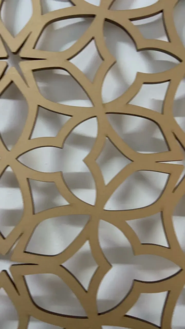 Close-up of a gold lattice of curved petals meeting at small stars, light falling through the openings