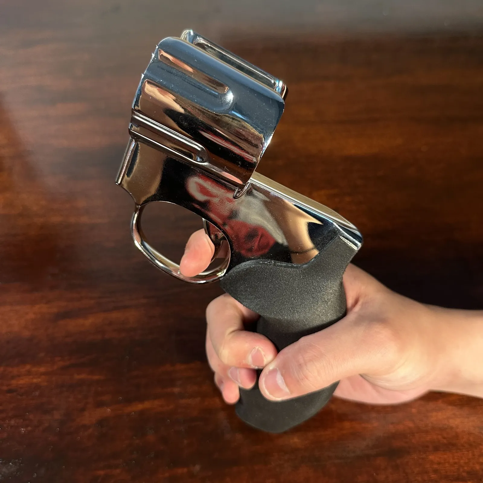 A hand holding the empty holder by its grip, showing the open chrome cylinder ring that takes the microphone