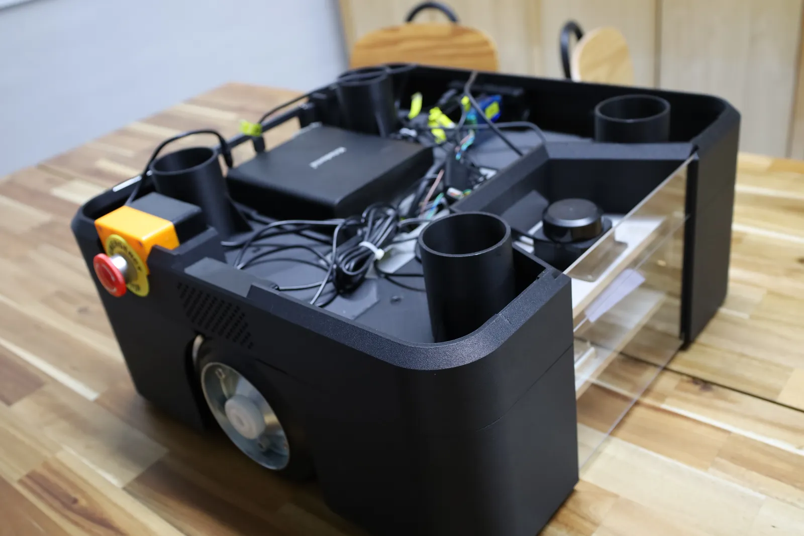 The cover with its top lifted off, showing the emergency stop mount, speaker grille and the AGV's wiring inside
