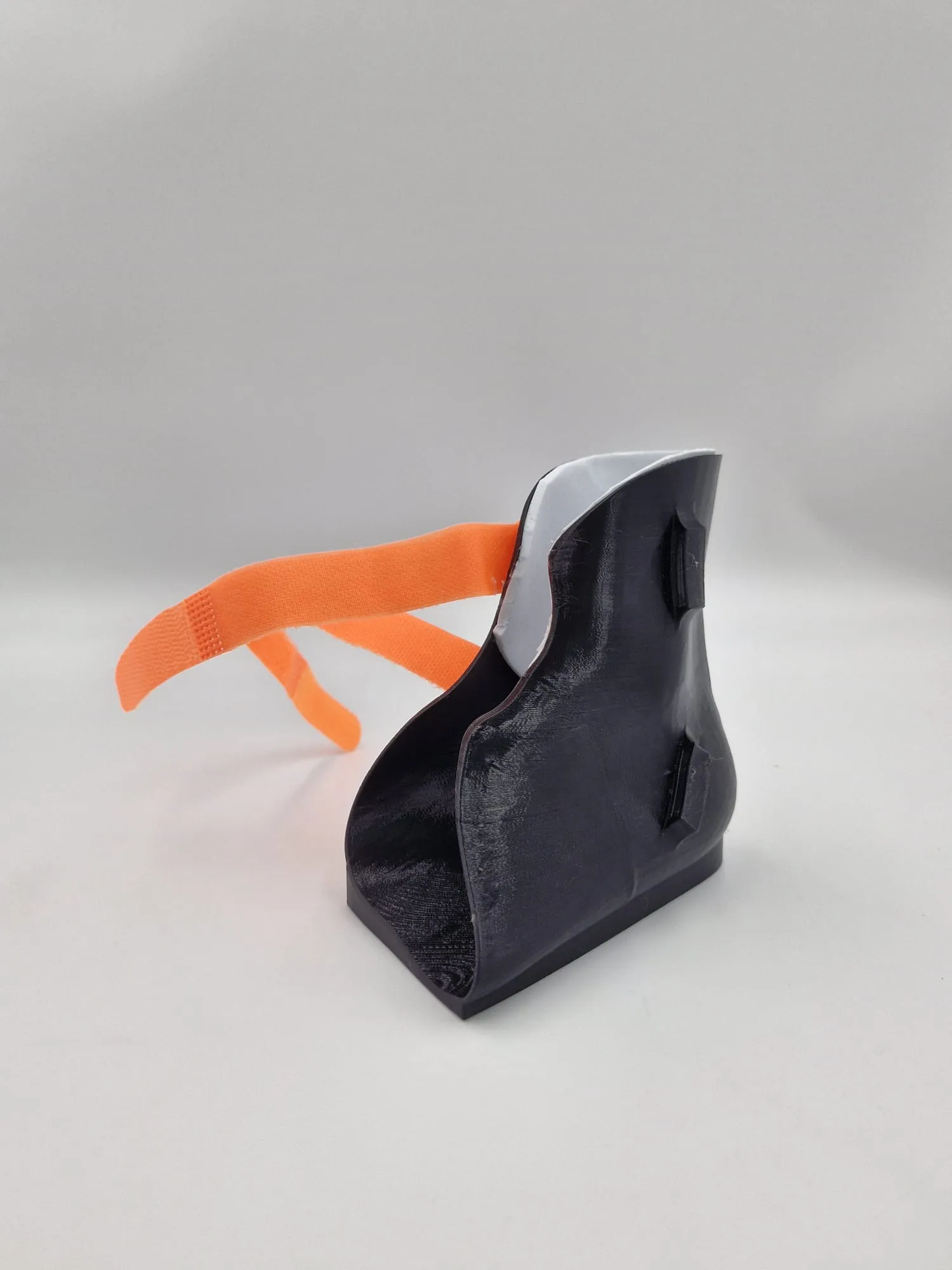 One strap undone, showing the strap slot in the side of the shell and the white lining at the top of the cuff