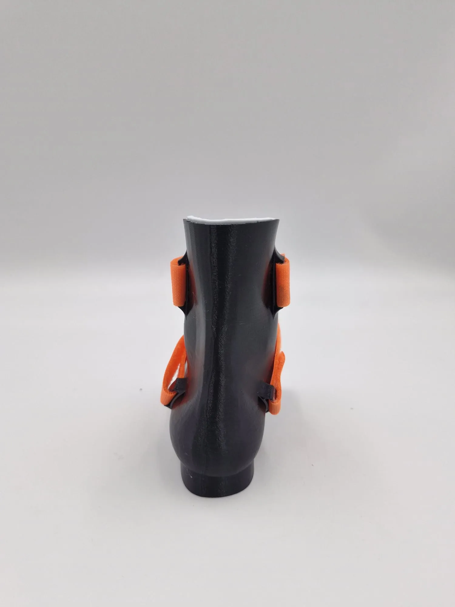 From behind: the smooth heel of the shell, with the strap ends held in slots on each side