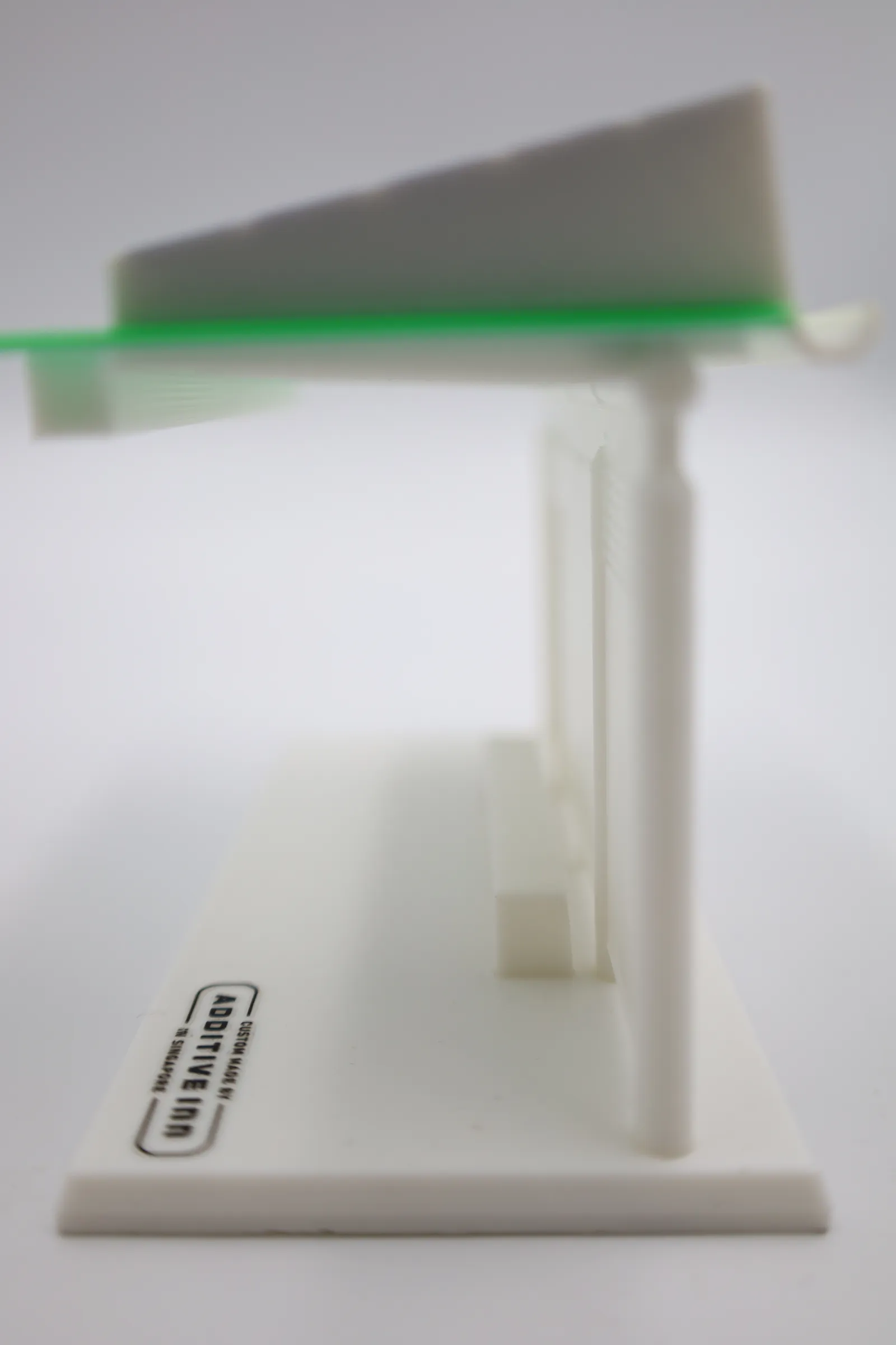 Side view of the assembled model: a white pillar holding the green roof plate and sloped solar block, with the gutter at one edge