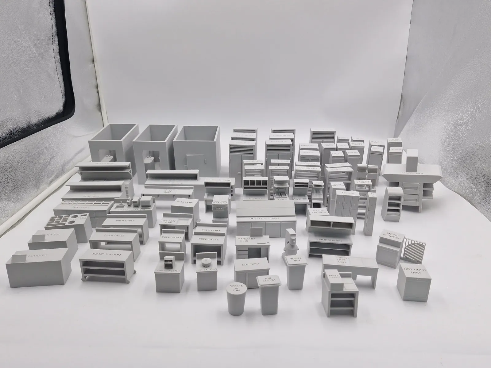 A full back-of-house set in light grey: walk-in rooms, fridges, make tables, sinks, ovens and storage racks laid out in rows