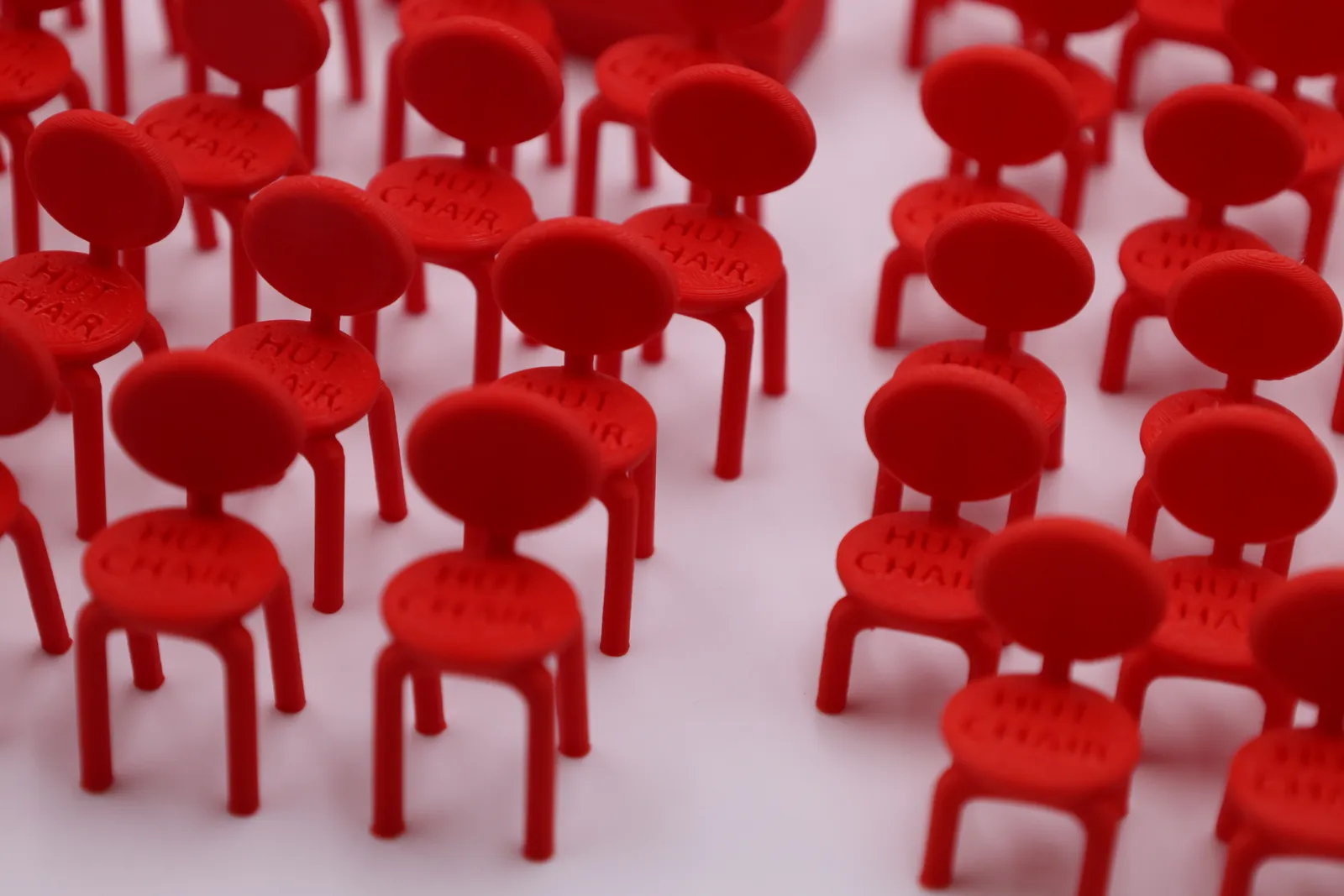 Rows of tiny red chairs, each with HUT CHAIR printed on the seat back
