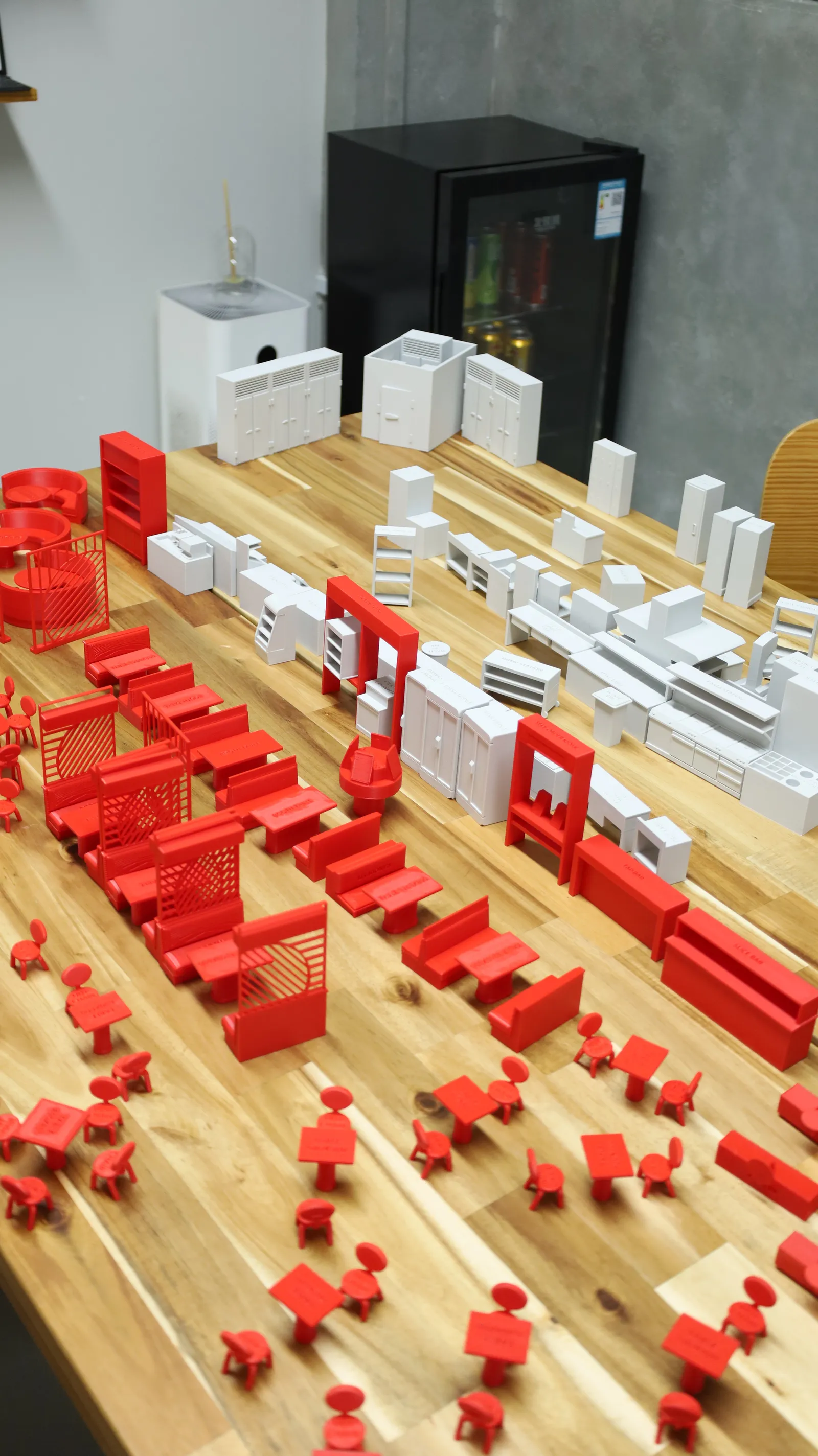 Red dining furniture and grey kitchen units laid out together on a table as a full restaurant floor plan