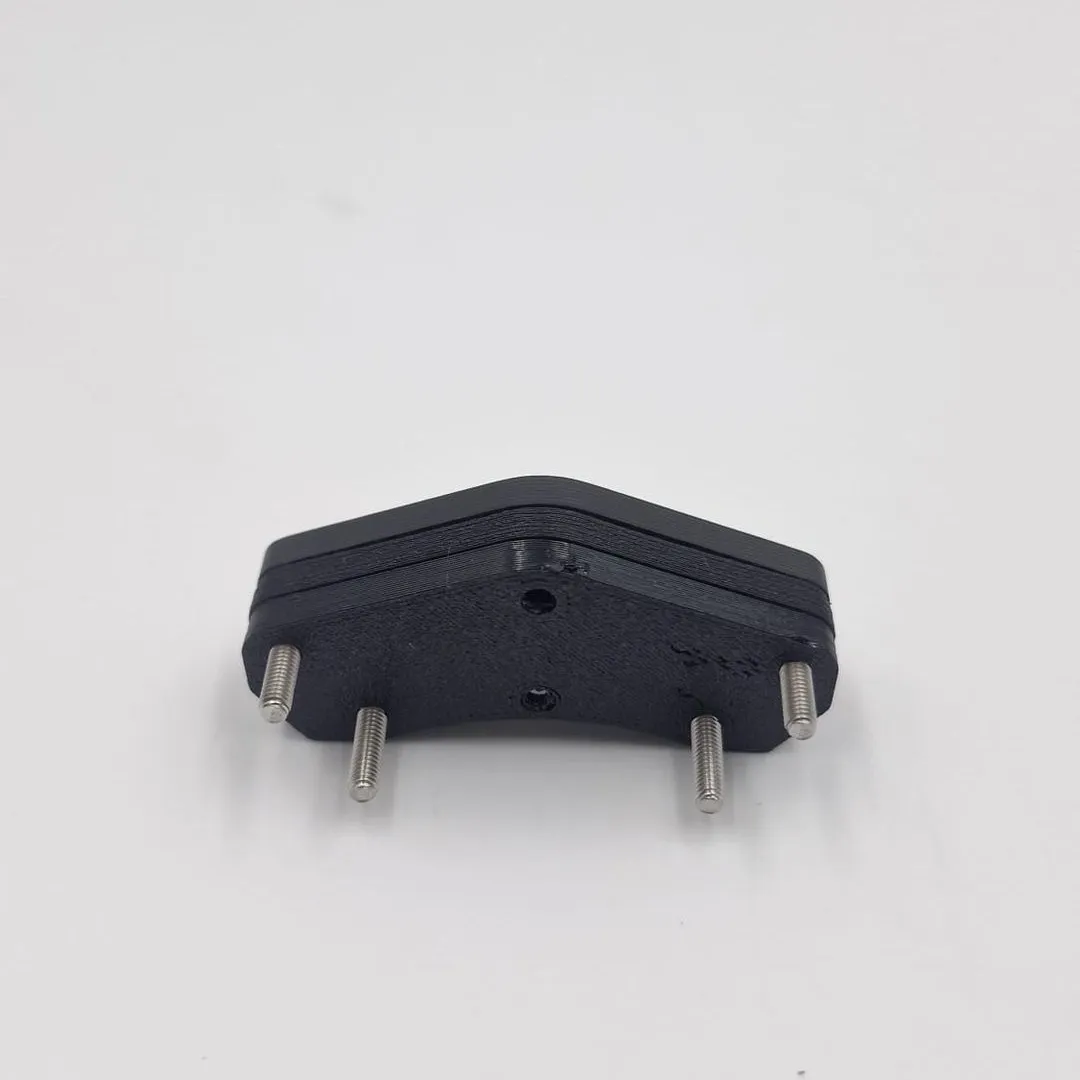 The four-stud bracket from the front, its angled top edge and the four steel studs pointing down