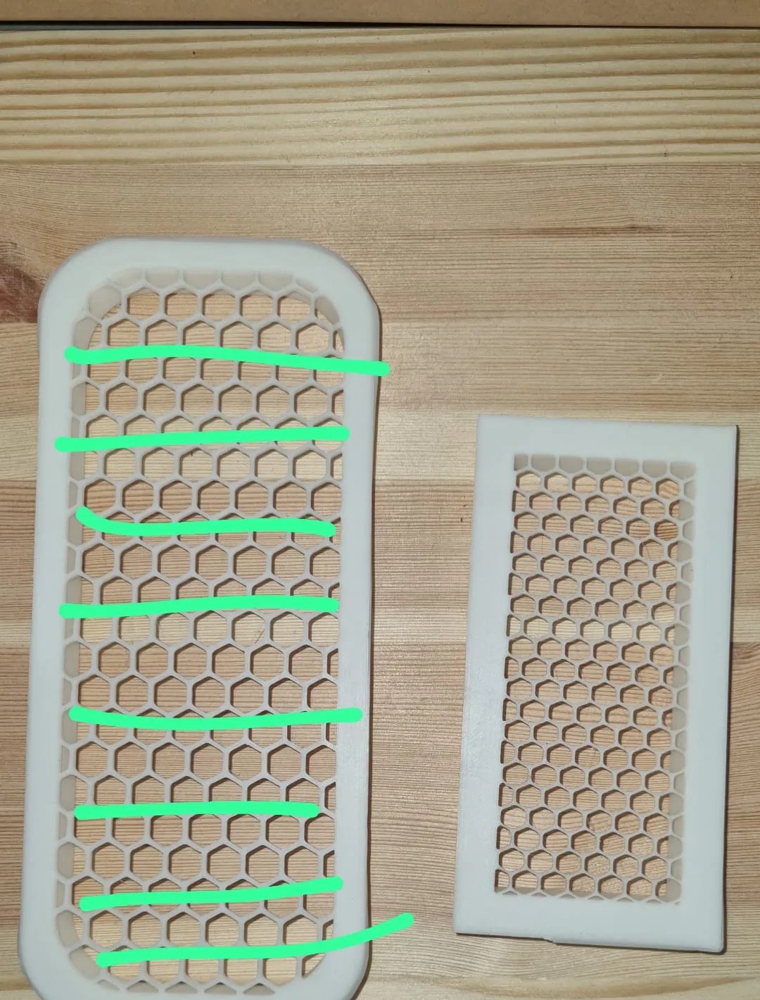Photo of the original large honeycomb vent marked with green lines where straight slats should replace the honeycomb, beside