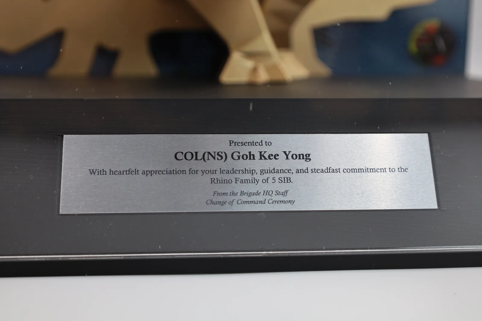 The metal plate on the gold trophy, presented to COL(NS) Goh Kee Yong from the Brigade HQ Staff at a Change of Command Ceremony