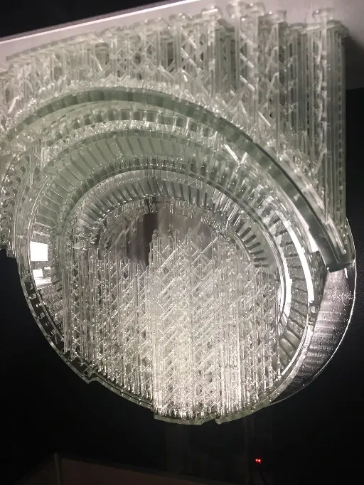 Close-up of the lattice of clear supports holding the model's arches and seating tiers to the build plate