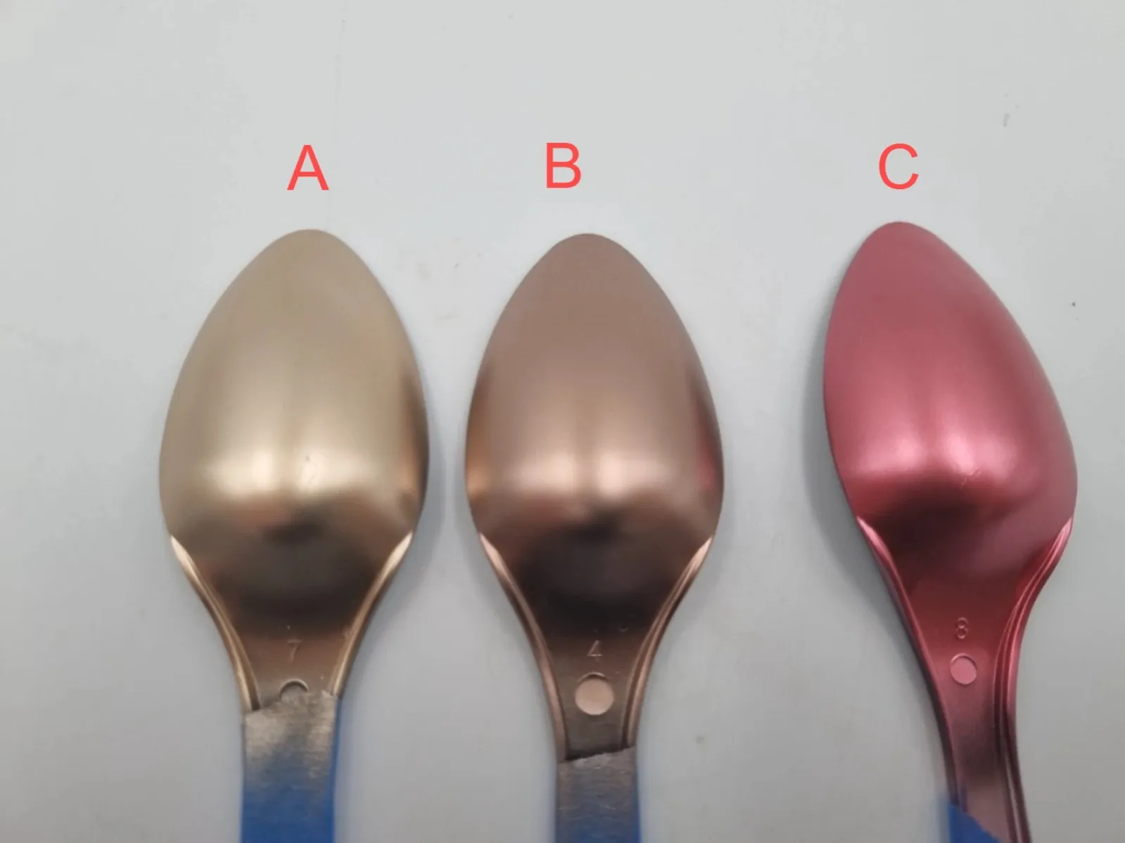 The three rose gold paint samples, A, B and C, sprayed on test spoons; sample B was chosen for the sign