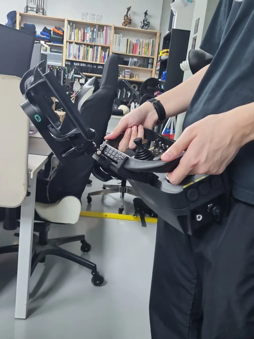 Someone in our studio holding the remote controller by its handles, with the prototype mount and tablet cradle fixed on top