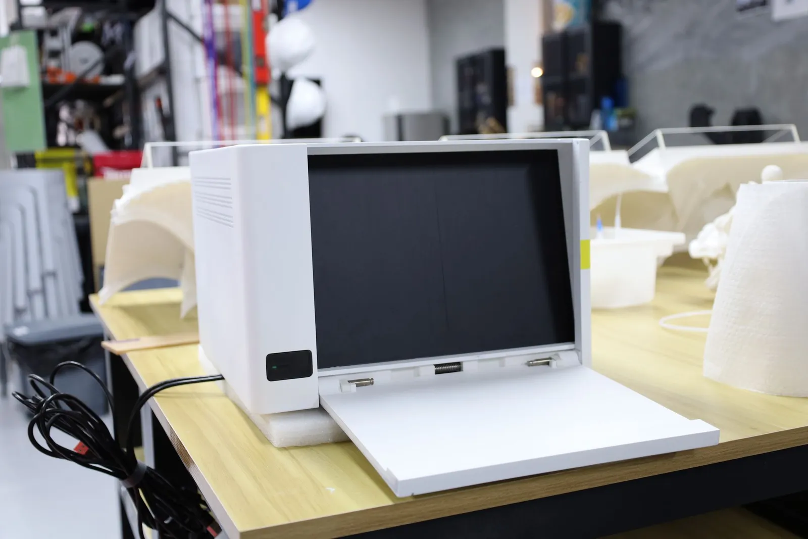 The Incucyte CX3 model on a workbench with its front folded fully down in front of the screen