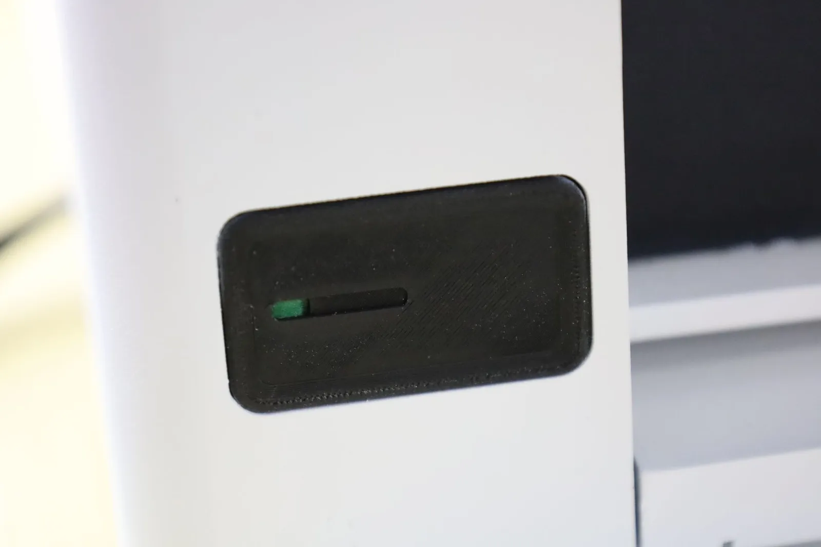 The black status light on the front of the Incucyte CX3 model, glowing green