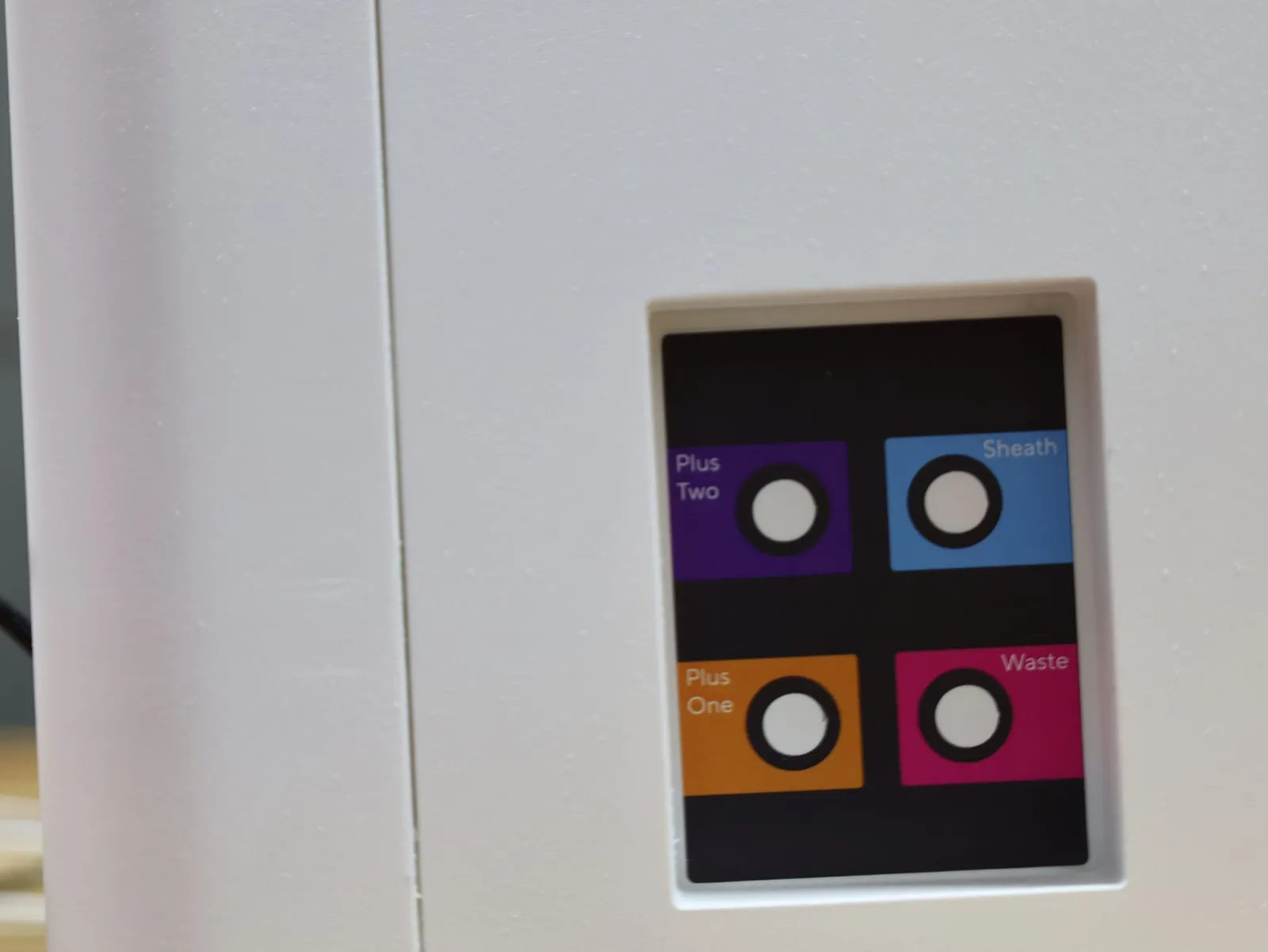 A small black panel on the side of the iQue 5 model with four round ports on purple, blue, orange and pink squares
