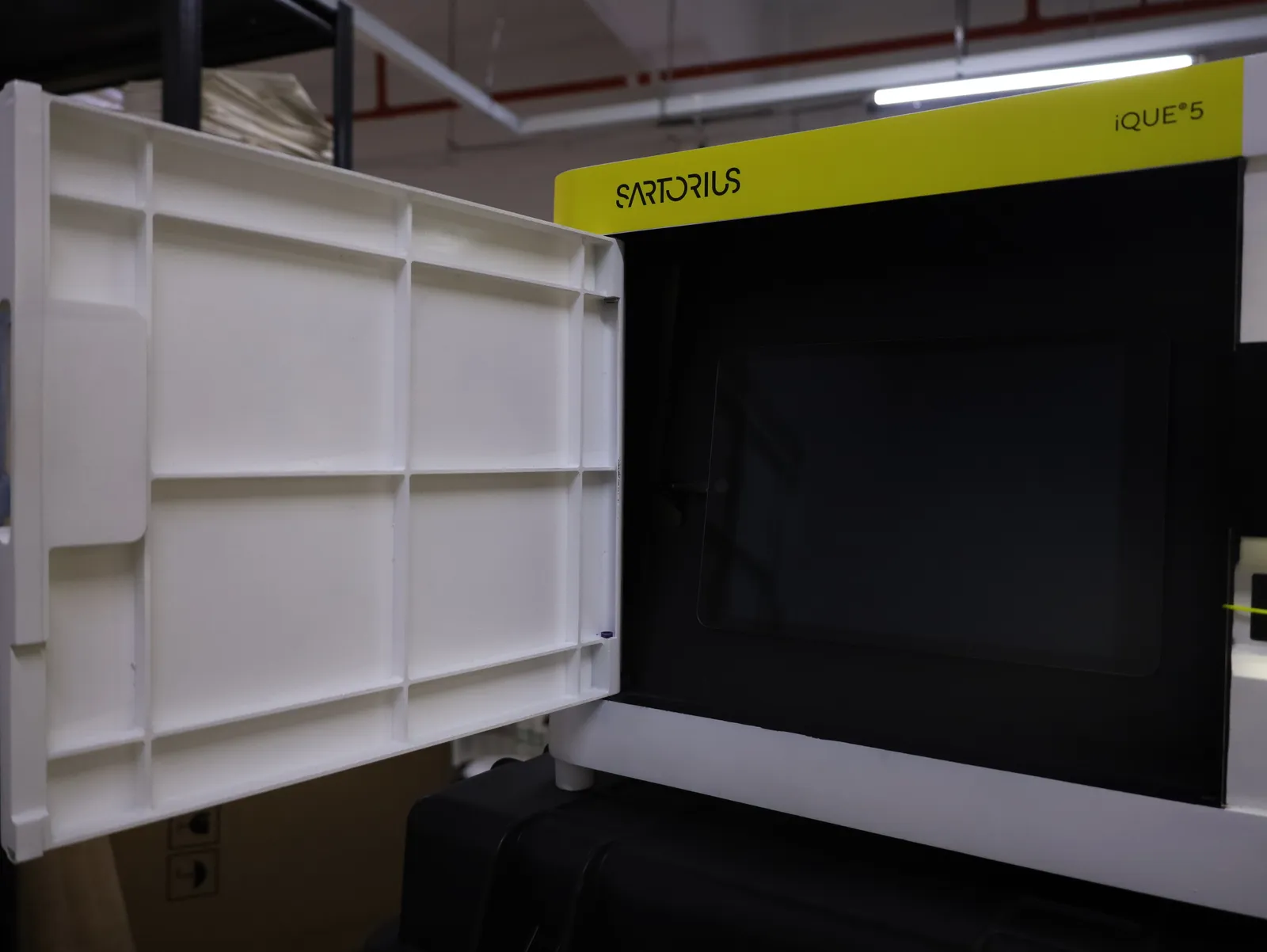 The iQue 5 model's front door swung open, its inside face showing the white printed ribbing in a grid, with the dark screen recess behind
