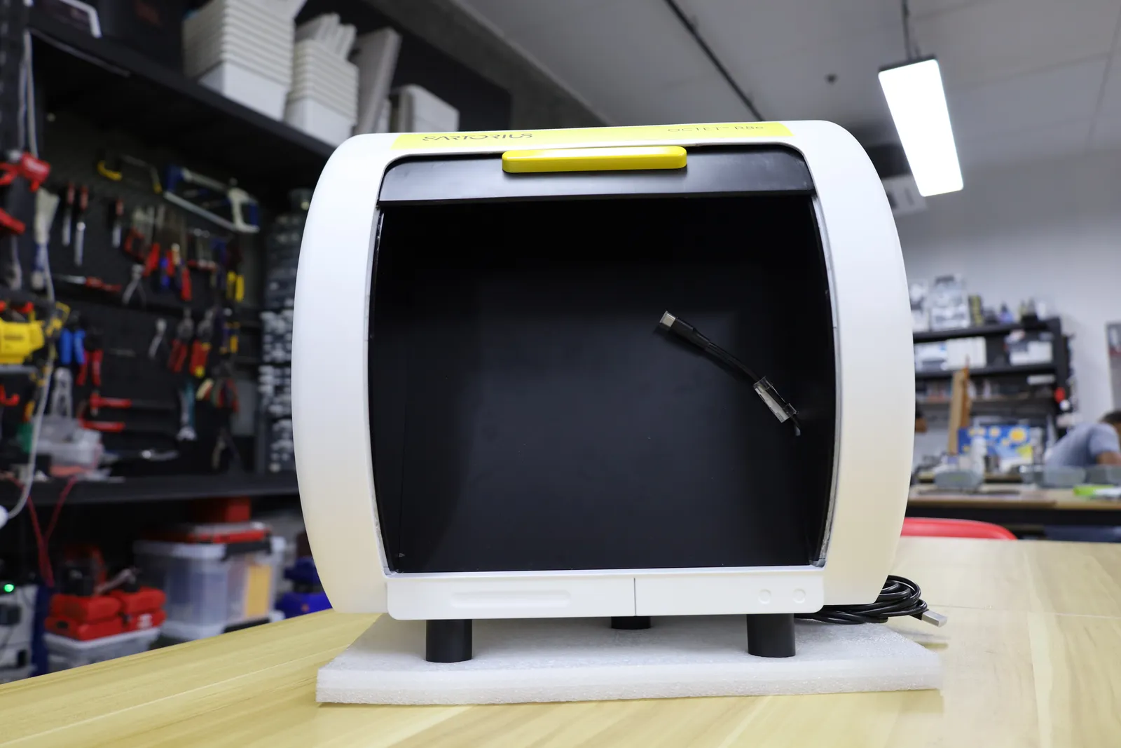 The Octet R8e model in the workshop, its front open on the empty black inside and the charging cable