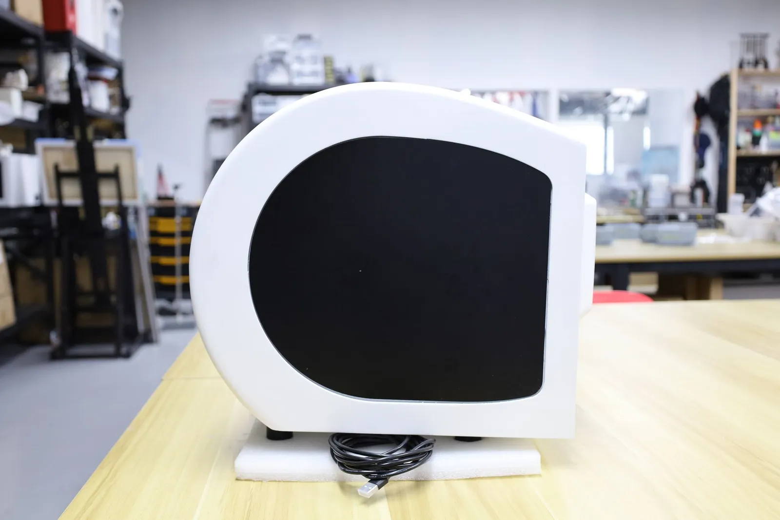 The Octet R8e model in side profile on a workbench, its white body rounded at the front with a dark window in the side