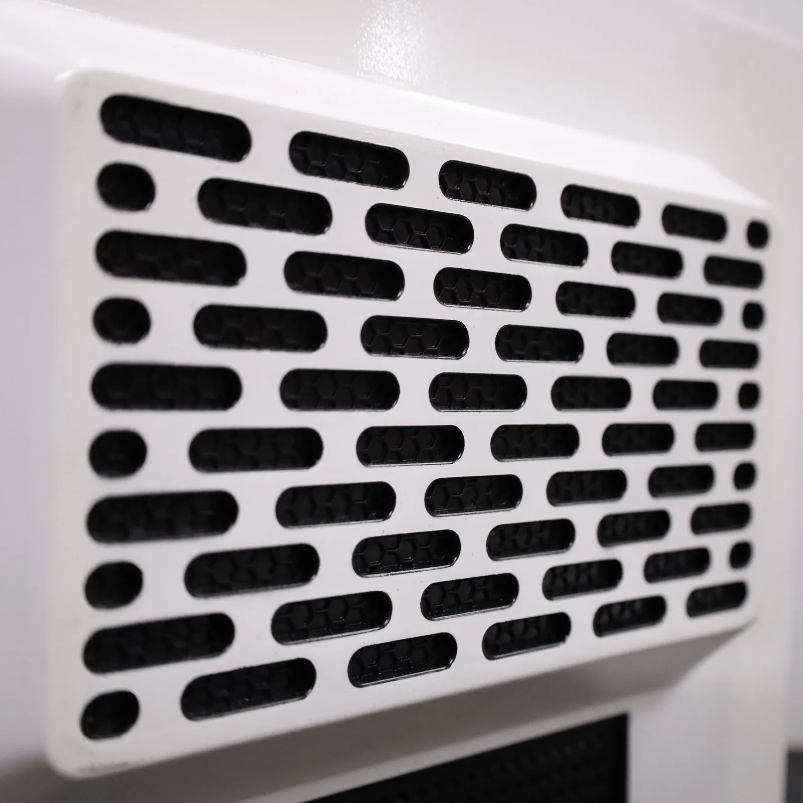 Close-up of the white vent grille on the back of the Octet R8e model, rows of rounded slots over a black backing