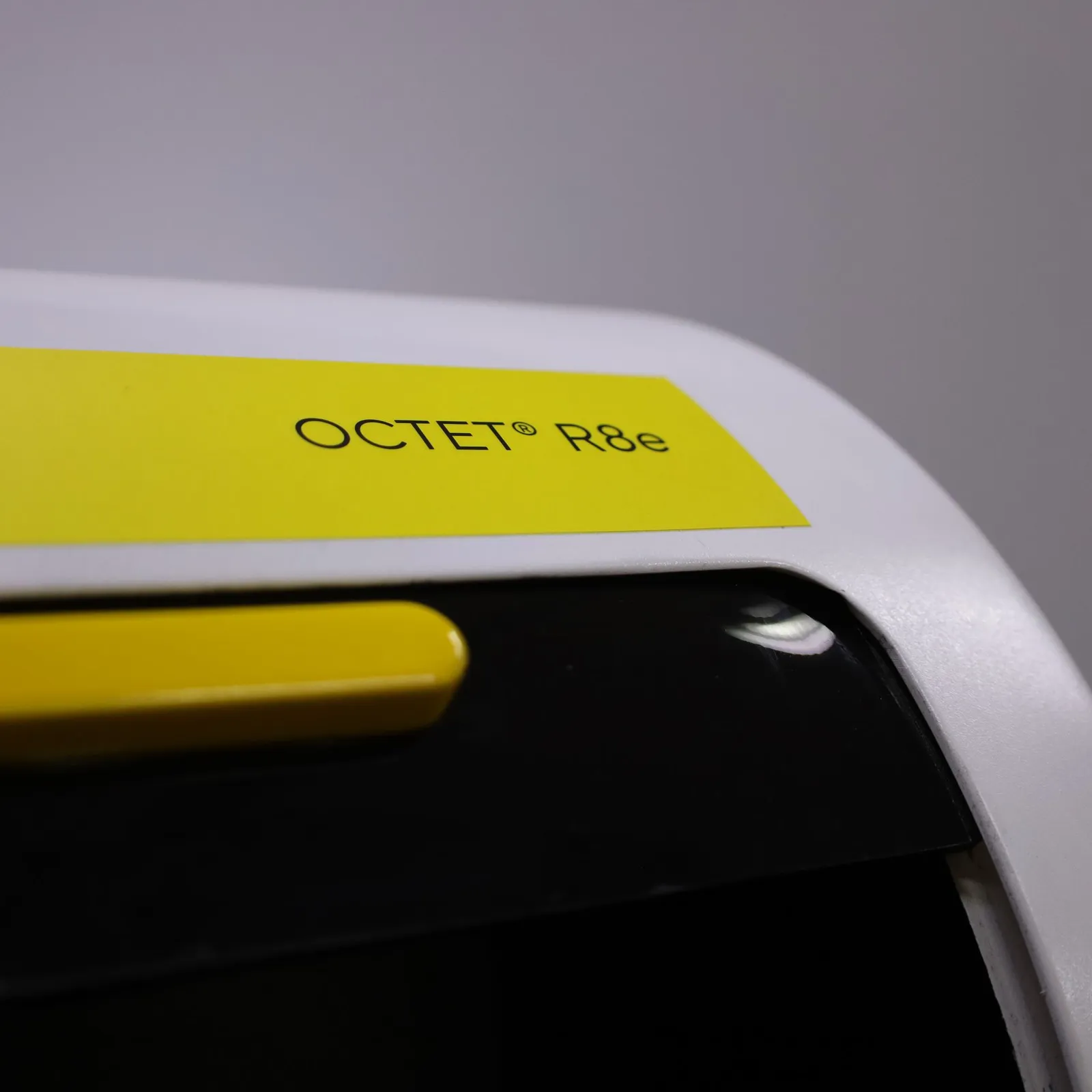 The yellow Octet R8e band on the curved top of the model, above the tinted door and its yellow handle