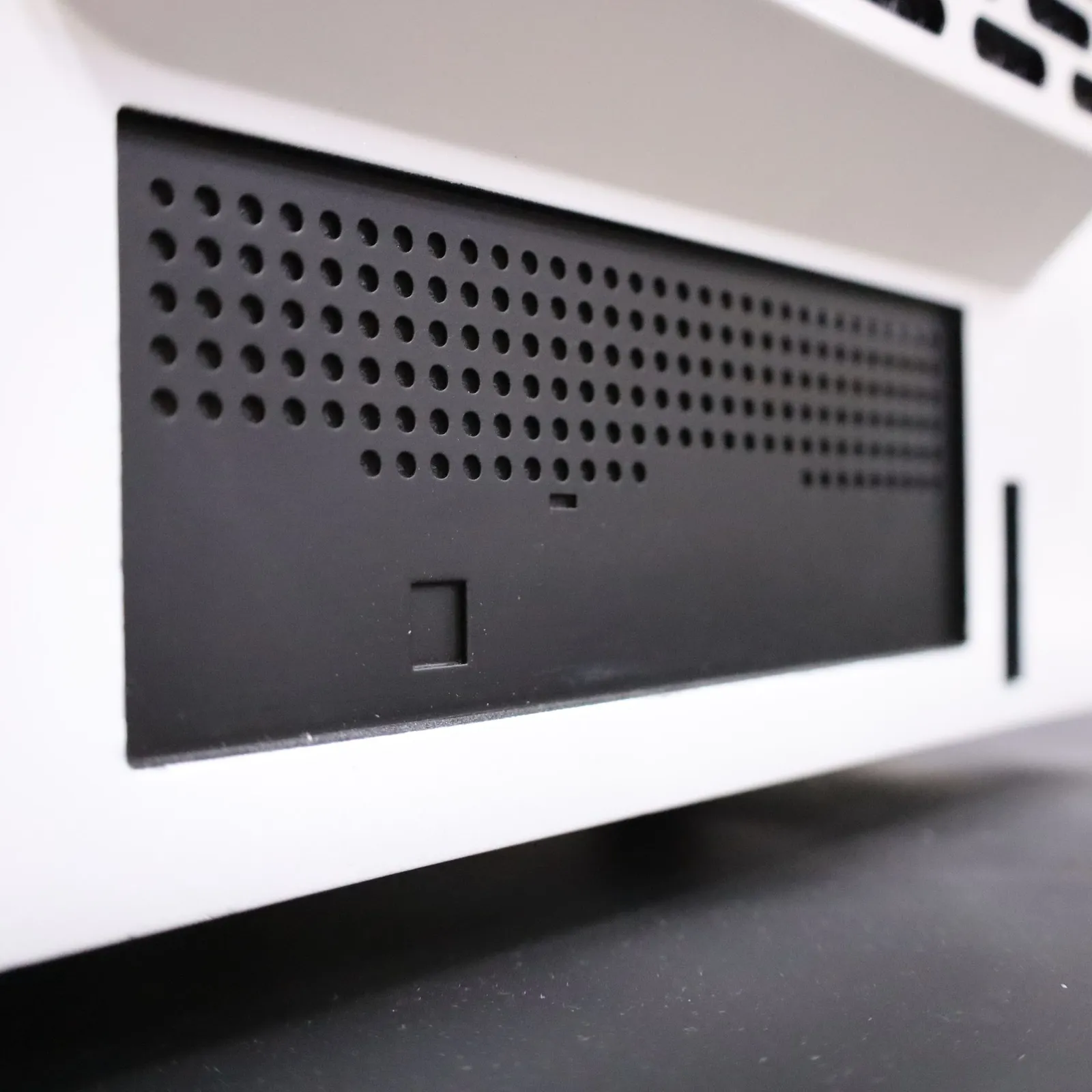 The black perforated panel low on the back of the Octet R8e model, below the vent grille