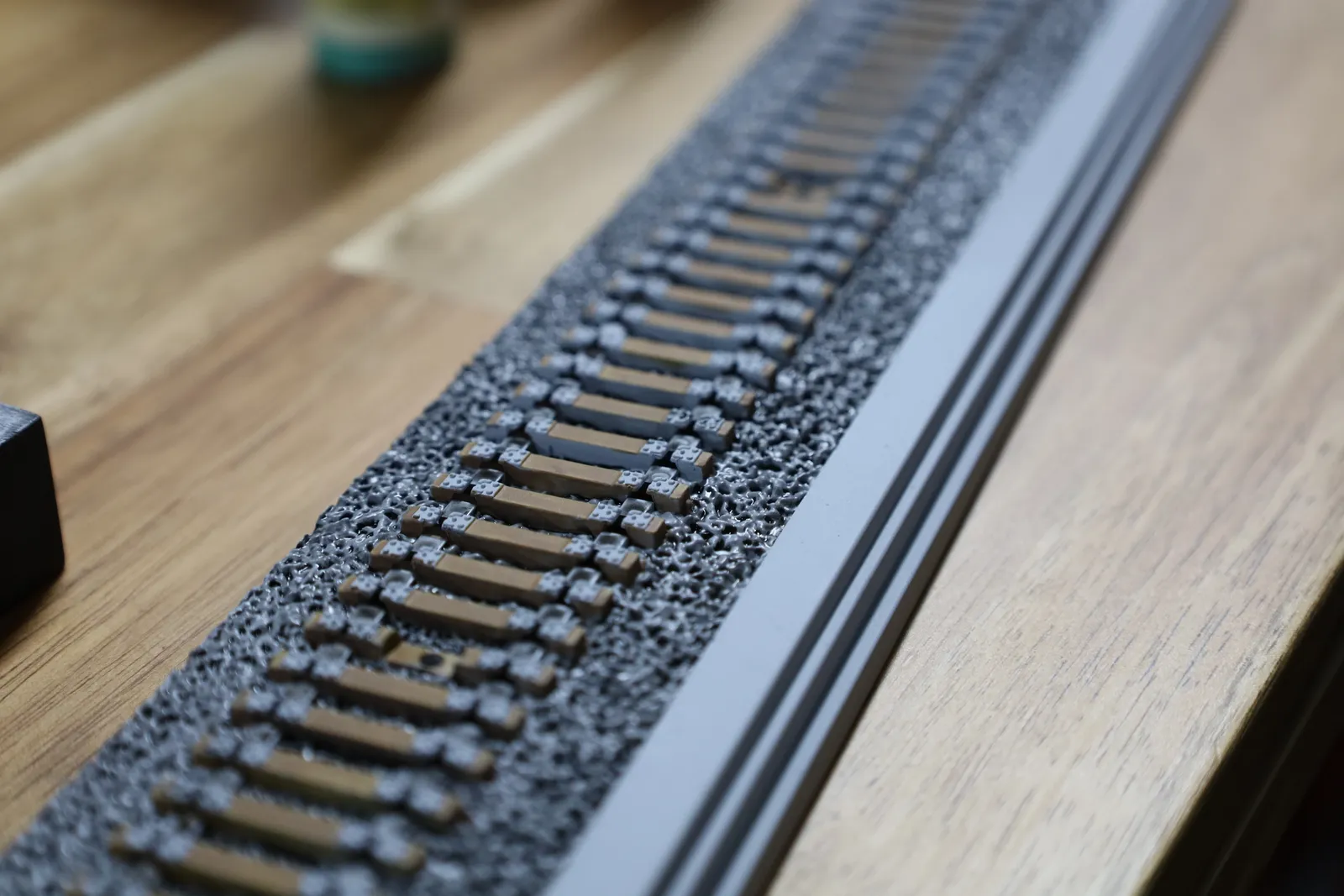 Close-up of the track: rows of brown sleepers on a bed of textured grey ballast