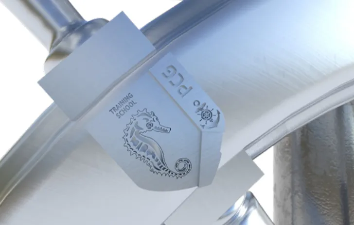 Close-up render of a PCG unit badge engraved into the silver rim, a seahorse for the Training School