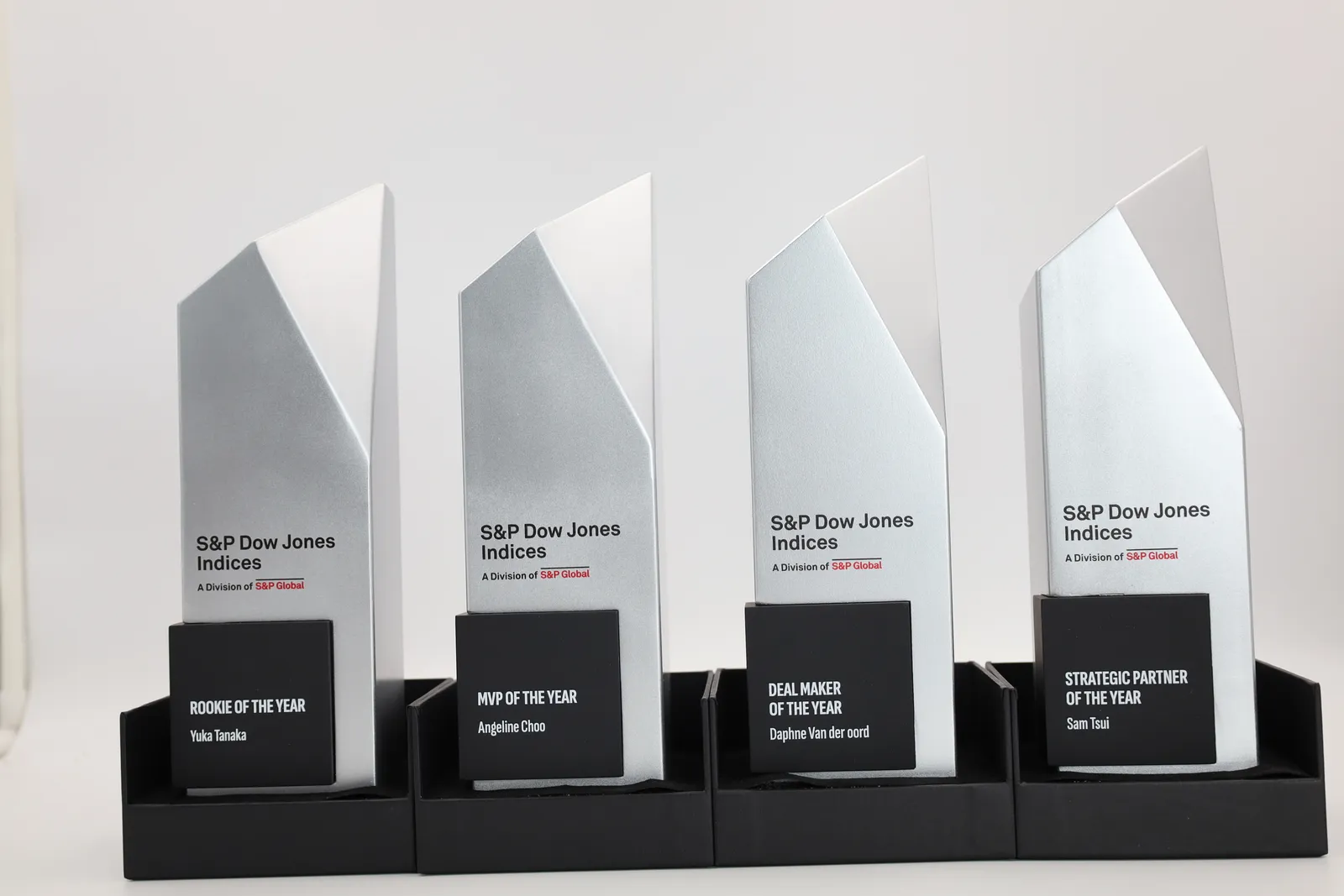 Four finished S&P Dow Jones Indices trophies in a row: angled silver columns with black plates for Rookie of the Year, MVP of the Year, Deal Maker of the Year and Strategic Partner of the Year