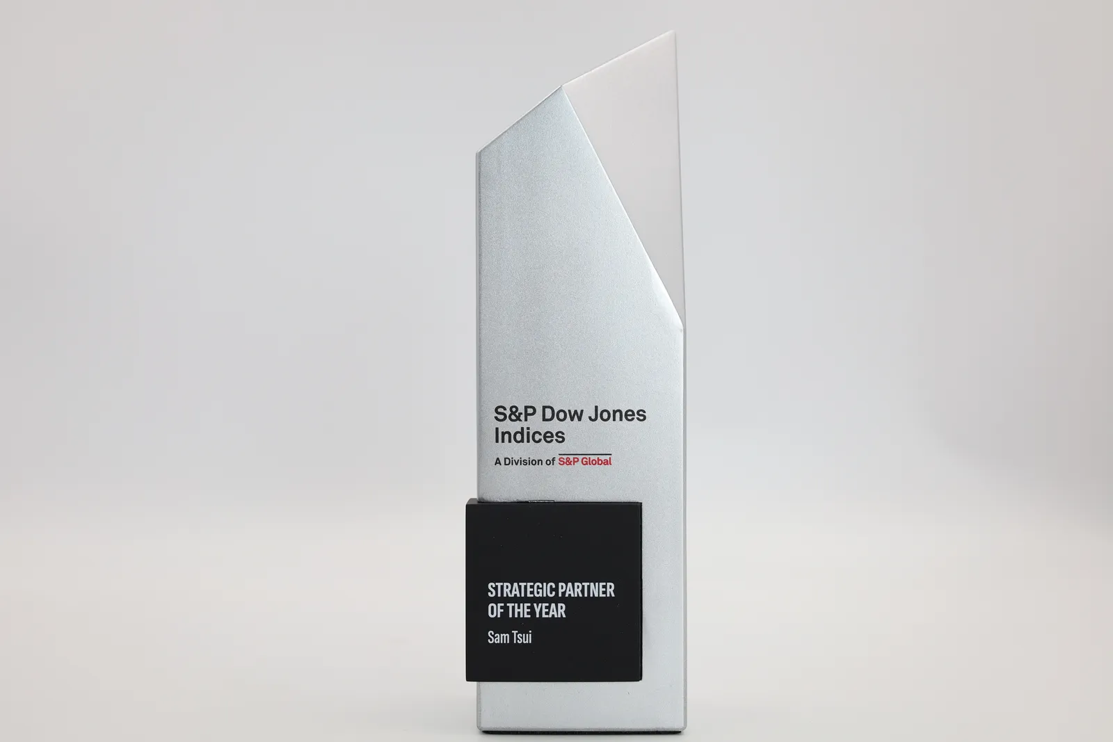 One finished trophy on its own: an angled silver column with the S&P Dow Jones Indices logo above a black Strategic Partner of the Year plate