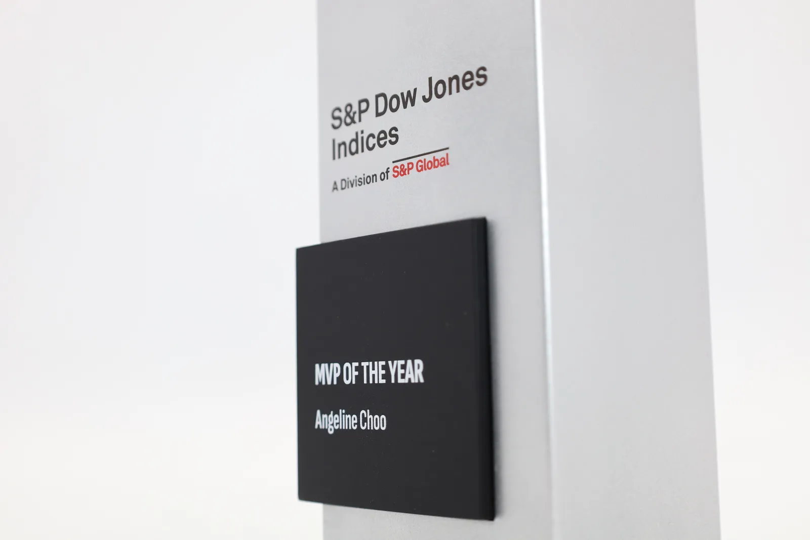 Close-up of a black plate reading MVP OF THE YEAR, Angeline Choo, below the S&P Dow Jones Indices logo