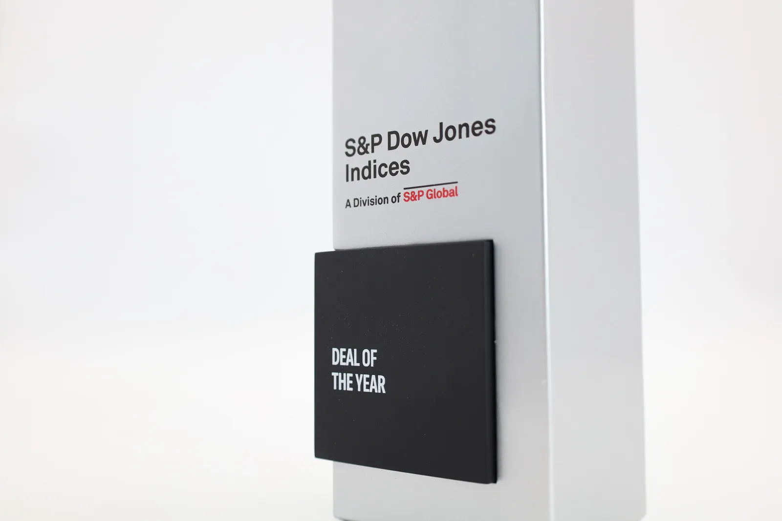 Close-up of a black plate reading DEAL OF THE YEAR with no name, below the S&P Dow Jones Indices logo