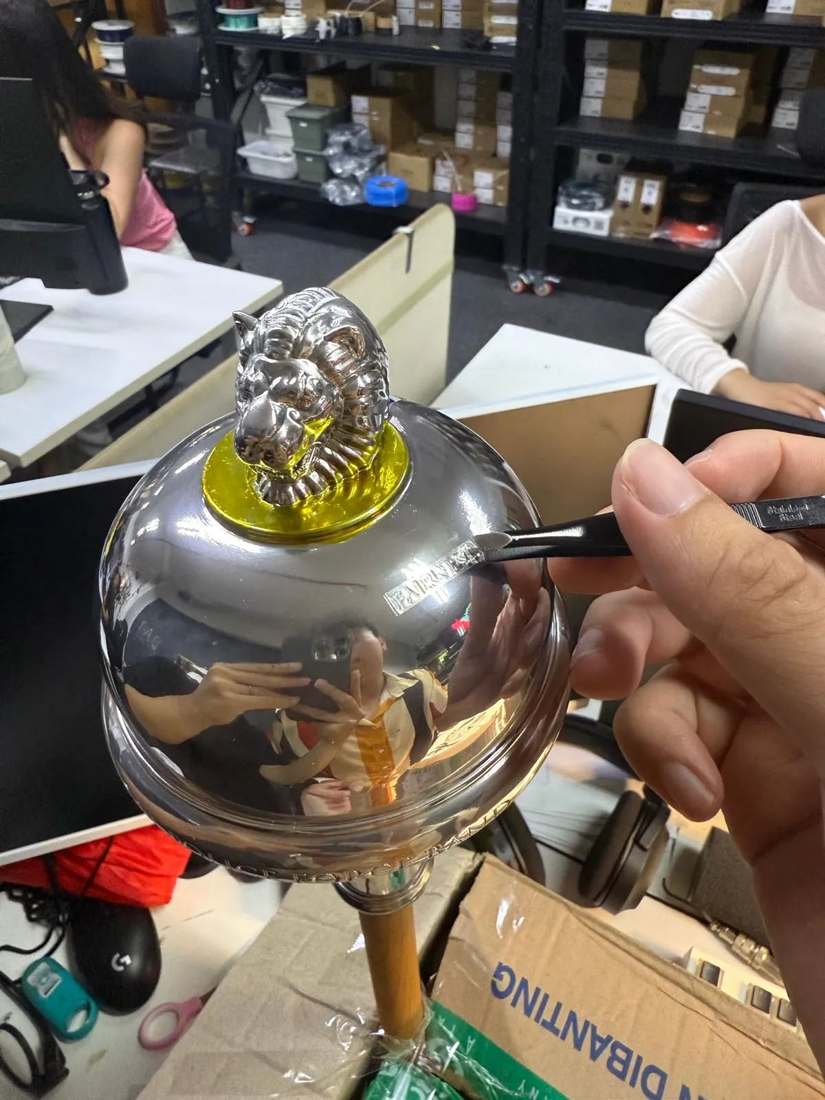 The chrome head on its wrapped shaft, a fine tool at the FAIRNESS lettering on the dome
