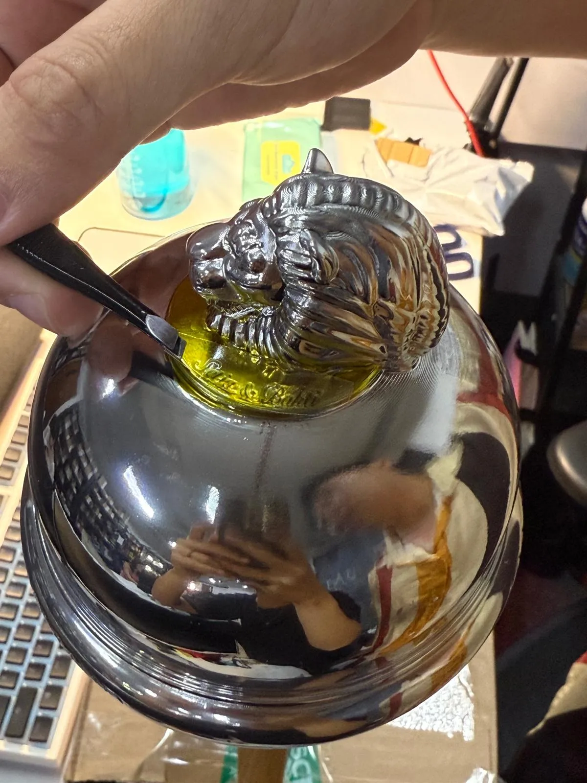 A fine tool working on the script lettering of the gold disc beneath the chrome lion