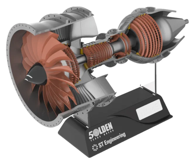Render of the cutaway engine, shaded copper to save render time, on two clear rods above a sloped black base with the Golden Years Ahead and ST Engineering logos and a blank plate