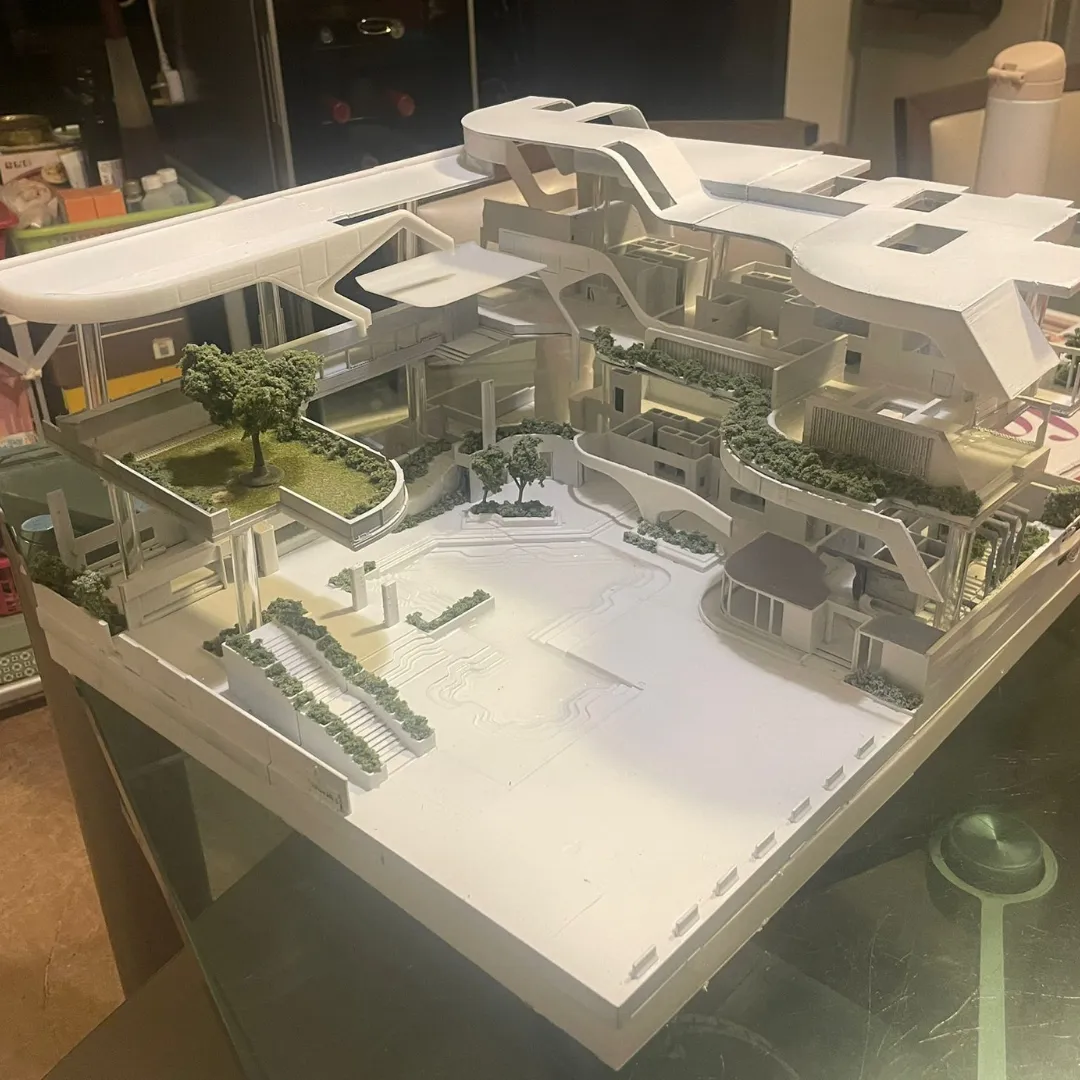 The finished model from a high corner, showing the curved roofs, the rooms under them and the wide plaza in front