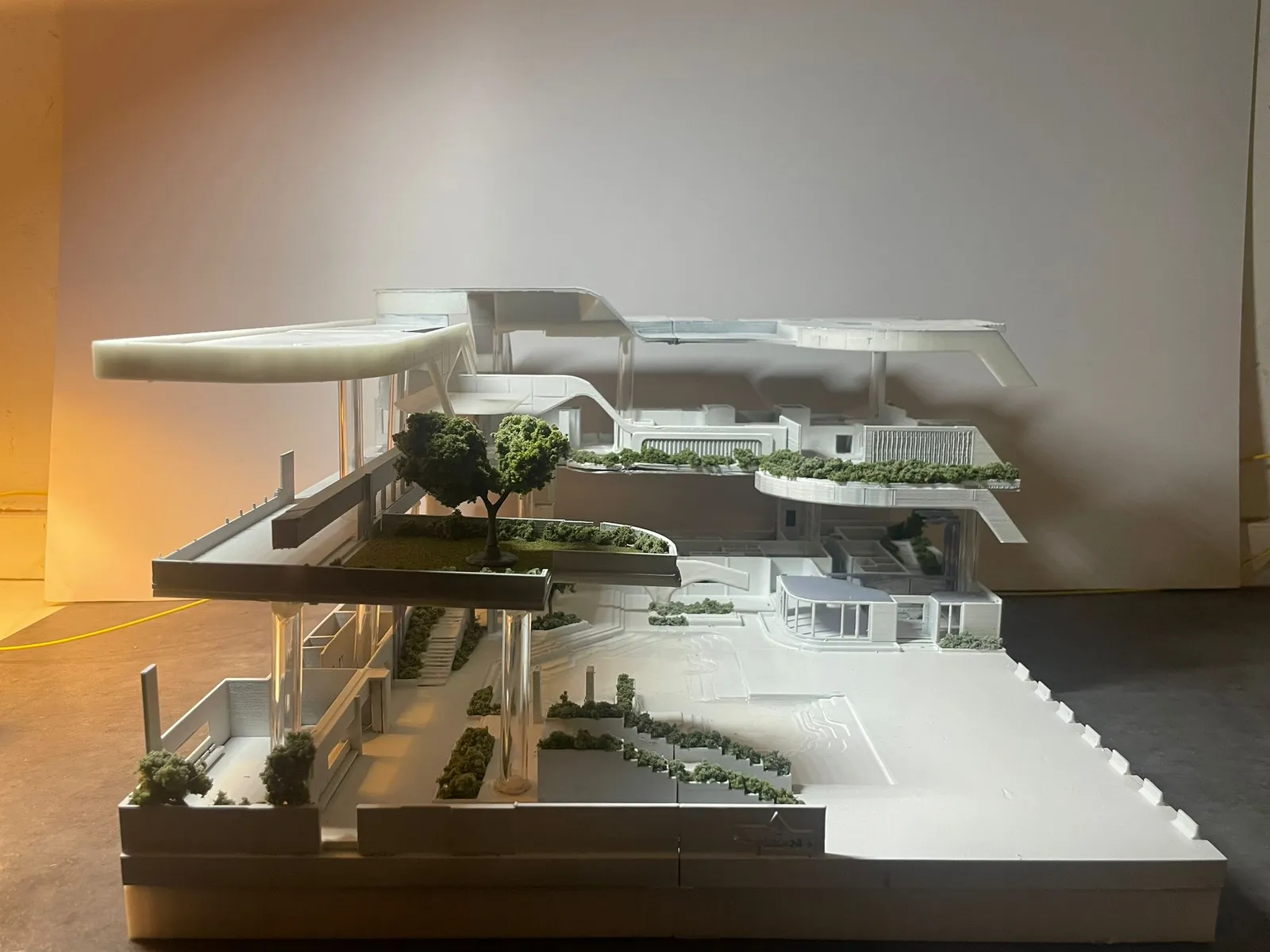 The assembled model at eye level: the upper deck with its tree on clear columns, planted stairs and the curved terraces beyond