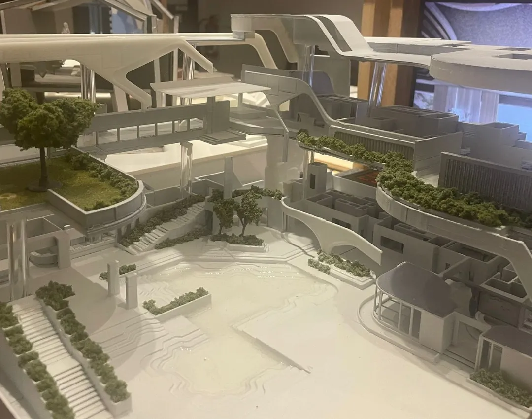 Looking across the sunken plaza: stepped edges, planted stairs, two small trees and the open levels behind