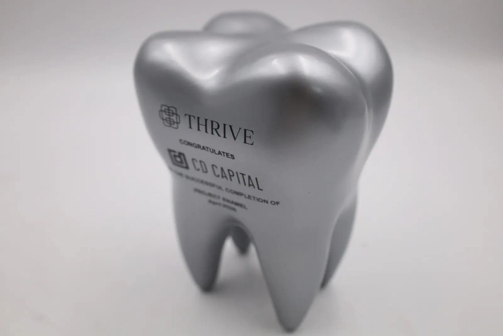 One tooth trophy from a three-quarter angle, showing the four roots it stands on and the shaped crown on top