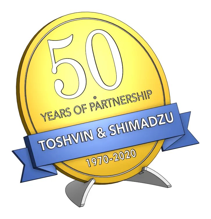 Render of the 3D mock-up: gold coin with a white 50 and YEARS OF PARTNERSHIP, a blue TOSHVIN & SHIMADZU banner and 1970-2020, on grey legs