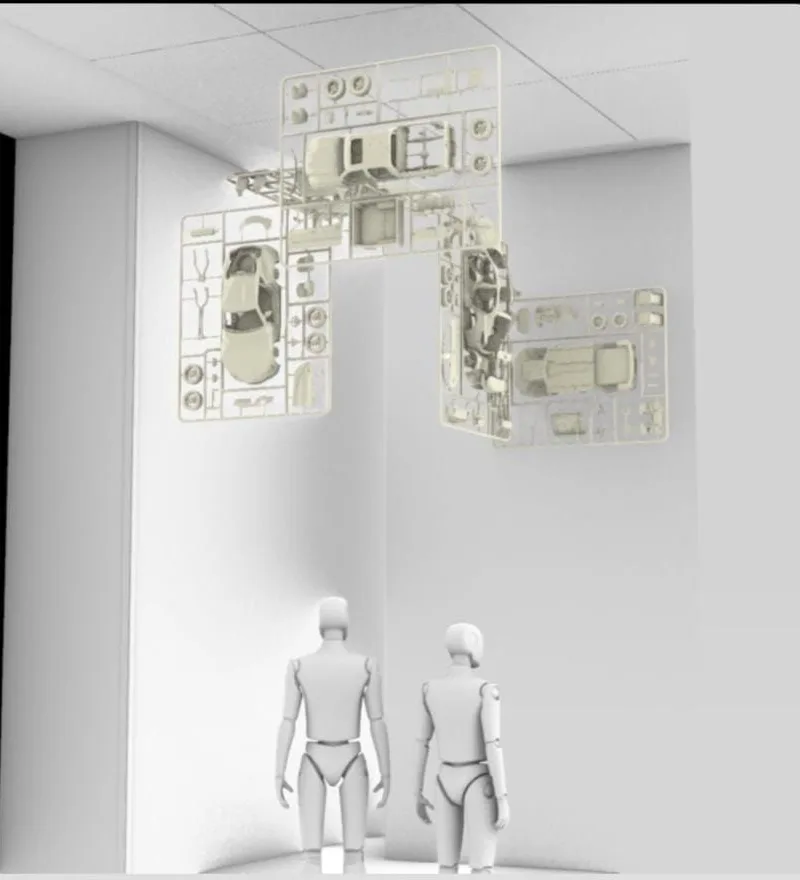 Render of four model car kits hung at angles from a white ceiling, with two figures standing below for scale