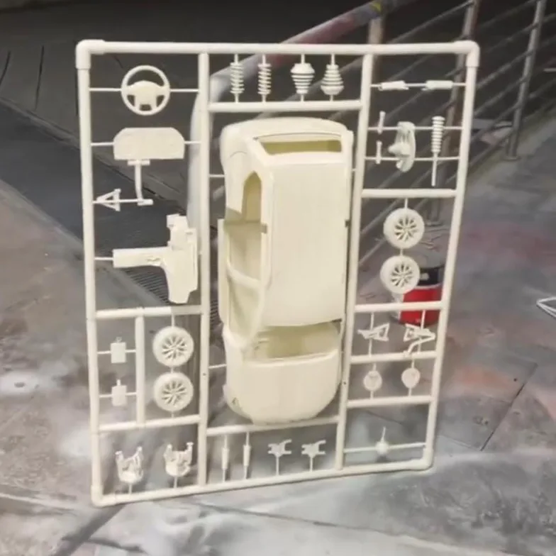 A finished car kit standing upright: the car body in the centre, wheels and parts around it on the frame