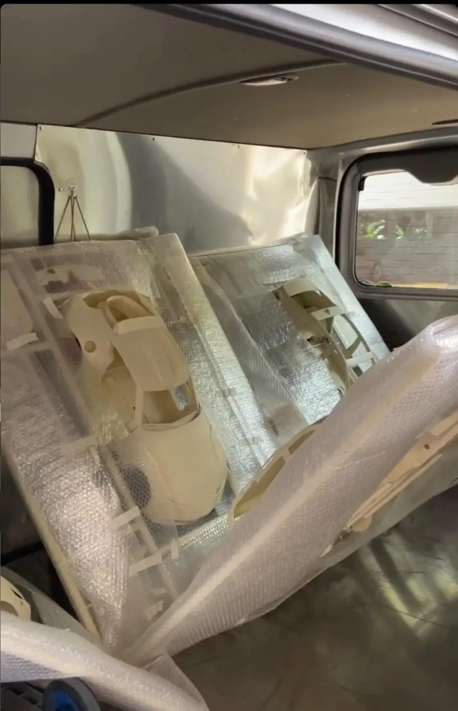 Finished car kits wrapped in bubble wrap, standing in the back of a van