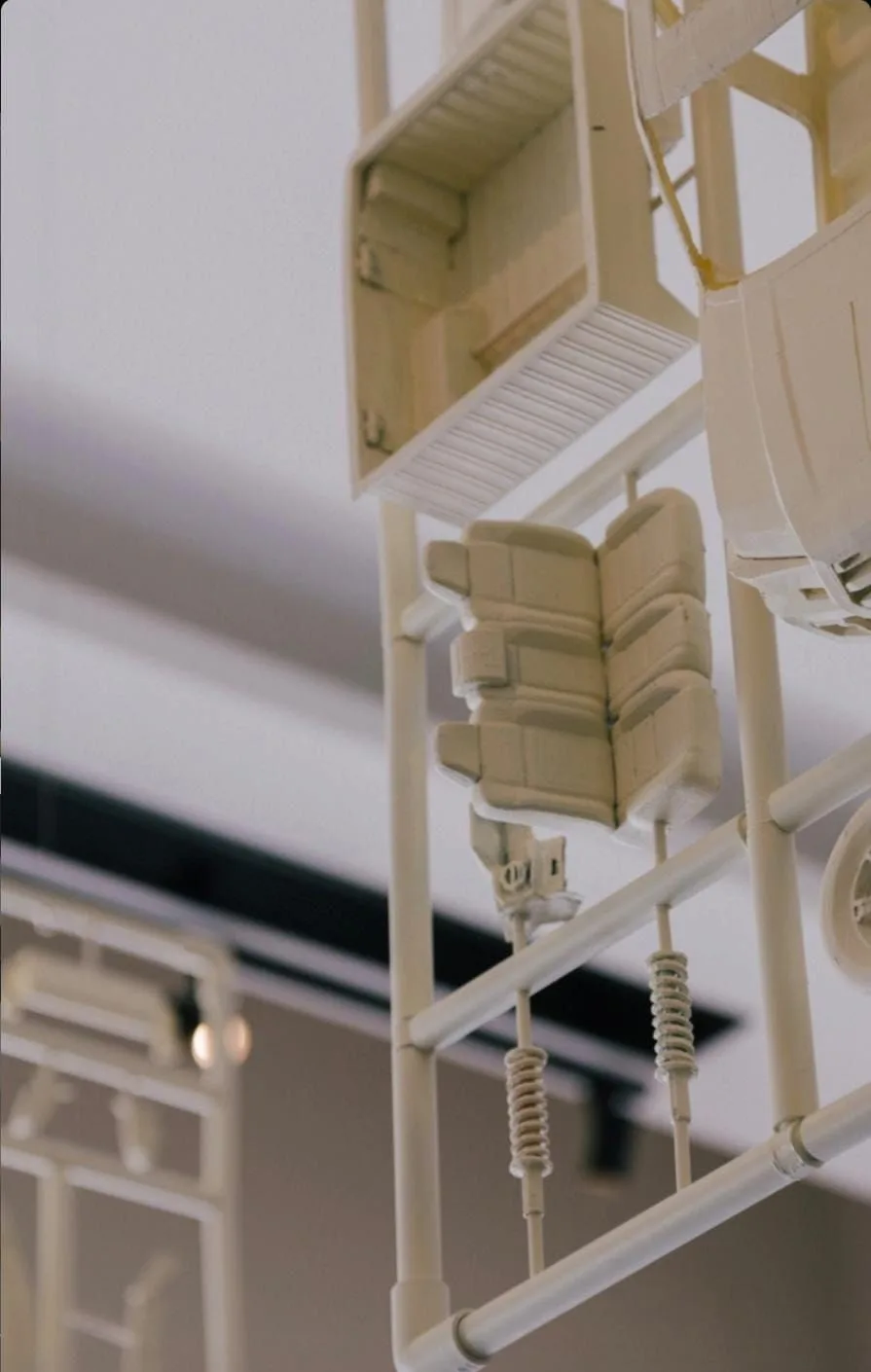Close-up of a hanging kit's seats, springs and doors on the frame, with another kit behind