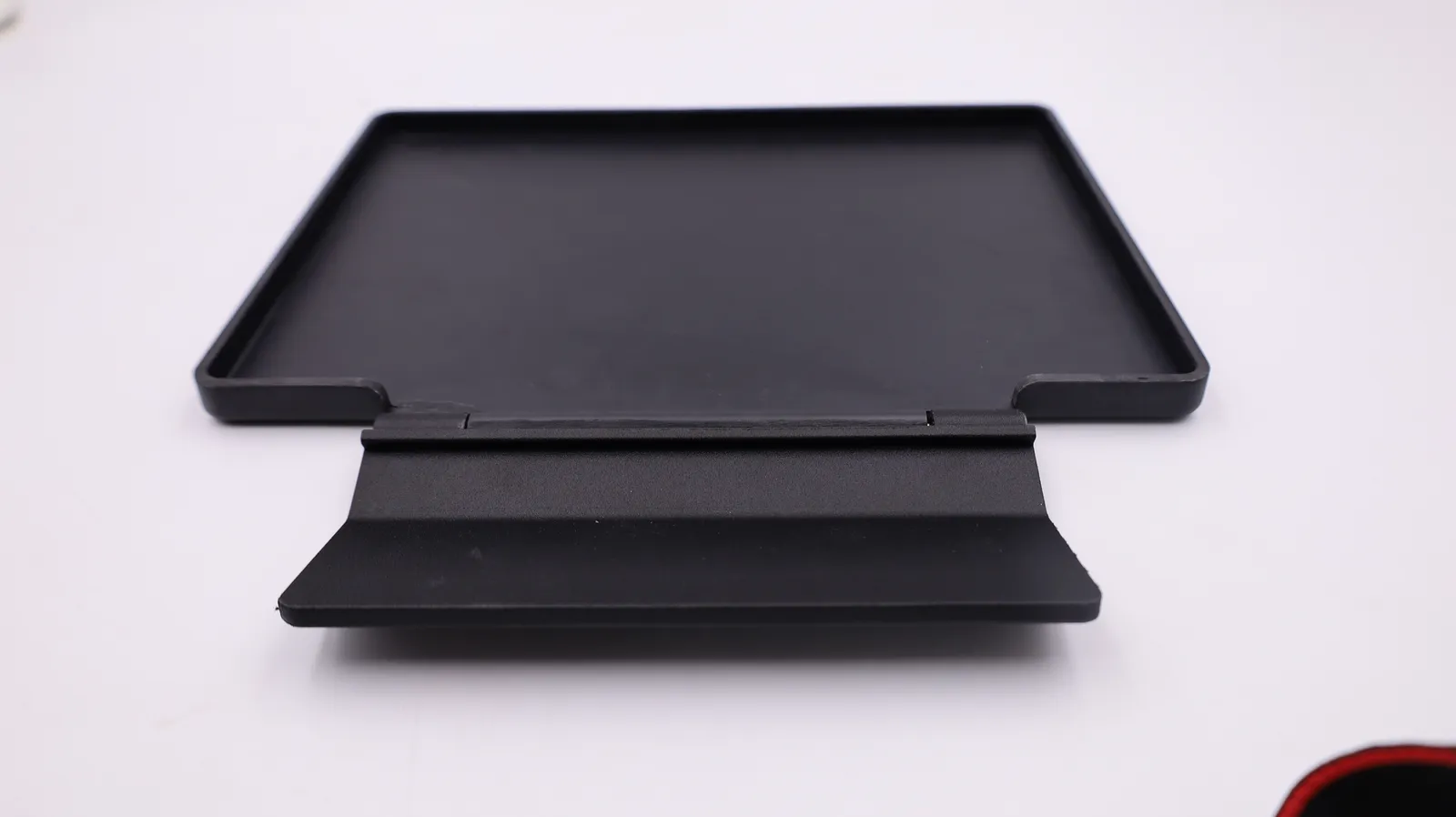 The assembled protector turned over: the inside of the front plate with its raised rim, hinged to the back plate
