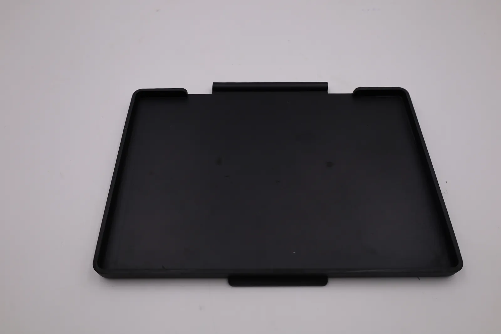 The inside of a front plate: a shallow tray with a raised rim that sits over the edge of the screen