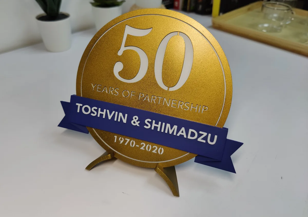 Gold 50 years of partnership medallion for Toshvin & Shimadzu