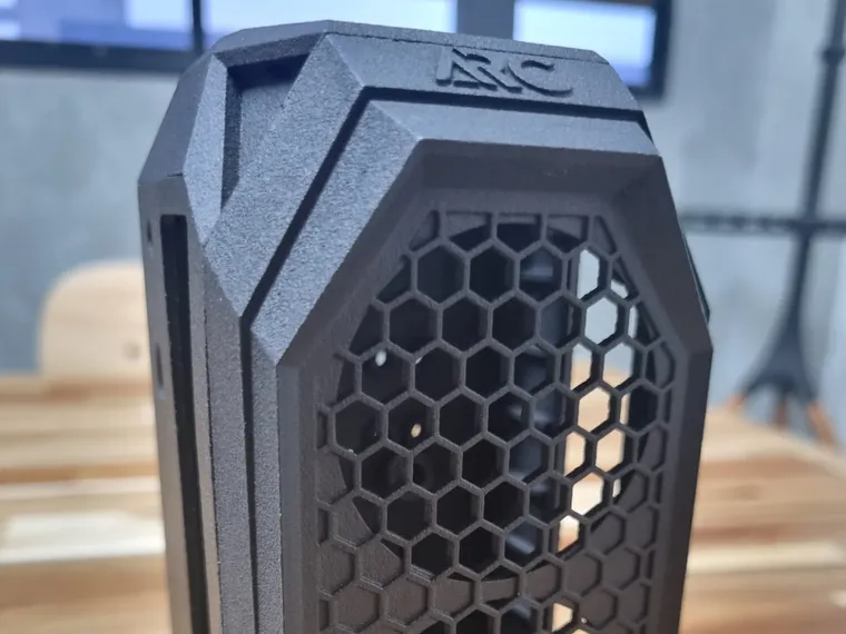 The Arc computer case in black nylon printed by Multi Jet Fusion (MJF), straight from the printer, with raised ARC lettering on the top cap above a fine honeycomb grille